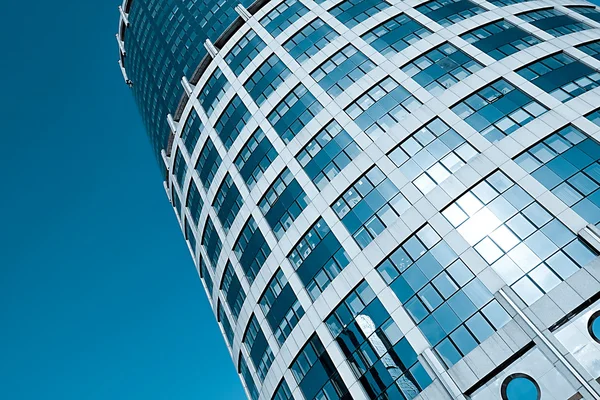Teksturowane wieża wieżowiec z odbiciem błękitne bezchmurne niebo — Zdjęcie stockowe