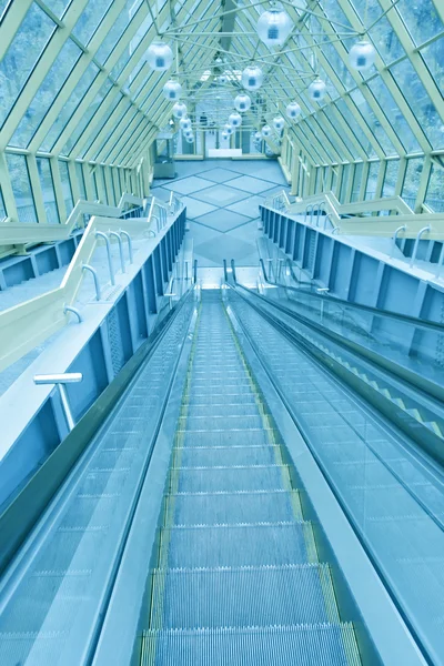 Abstrakte Schritte einer grünen Rolltreppe mit Personen an der Spitze — Stockfoto