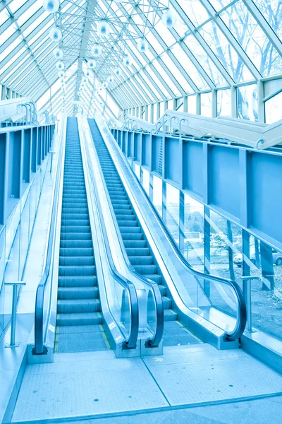 Escalones abstractos de escaleras mecánicas verdes con personas en la parte superior —  Fotos de Stock