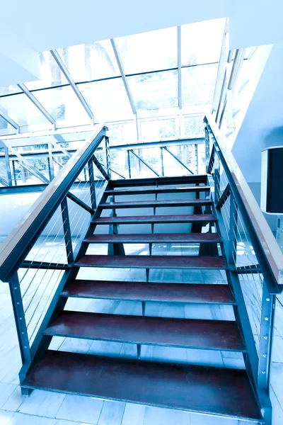 Деревянные ступени роскошной бизнес-лестницы в голубом офисном коридоре — стоковое фото