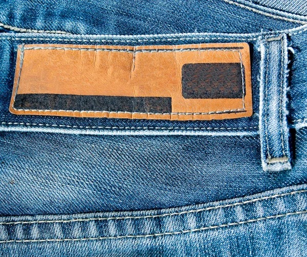 Mavi jeans ile boş deri etiket — Stok fotoğraf