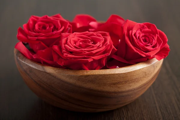 Rosas rojas en cuenco de madera — Foto de Stock