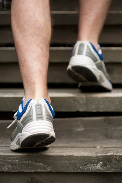 Las piernas del hombre corriendo en las escaleras — Foto de Stock