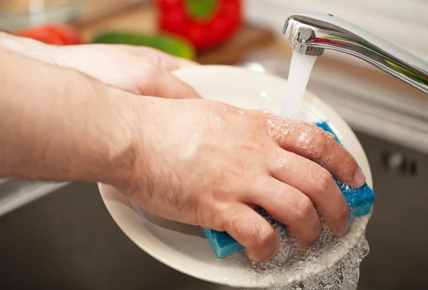 Las manos del hombre lavando platos — Foto de Stock
