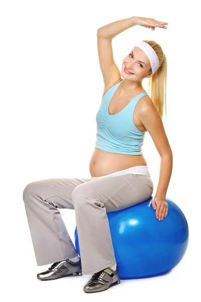 Giovane donna incinta che fa esercizio su una palla fitness — Foto Stock