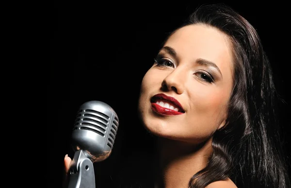 Portrait of a beautiful brunette with a retro microphone — Stock Photo, Image