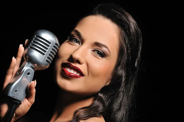 Portrait of a beautiful brunette with a retro microphone — Stock Photo, Image