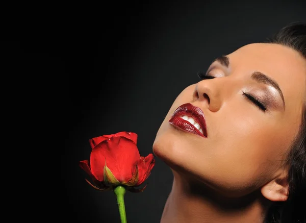 Retrato de uma bela mulher com uma rosa vermelha — Fotografia de Stock