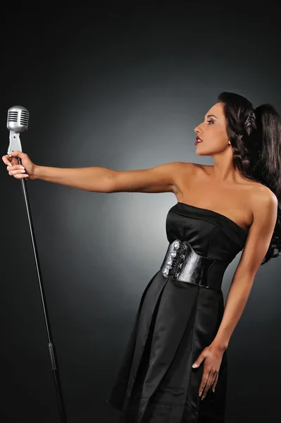 Attraktiv brunett kvinna med en retro mikrofon — Stockfoto