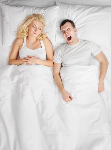 Junges Paar schläft in einem Bett — Stockfoto