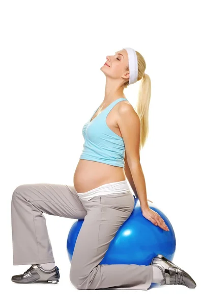 Jovem grávida fazendo exercício em uma bola de fitness — Fotografia de Stock