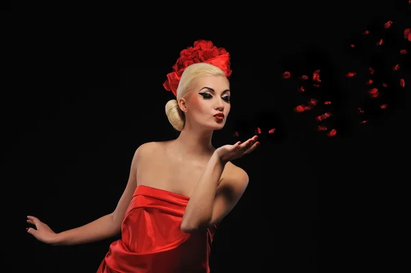 Krásná žena, foukání růží — Stock fotografie