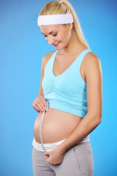 Hamile kadın göbeğini ölçer. — Stok fotoğraf