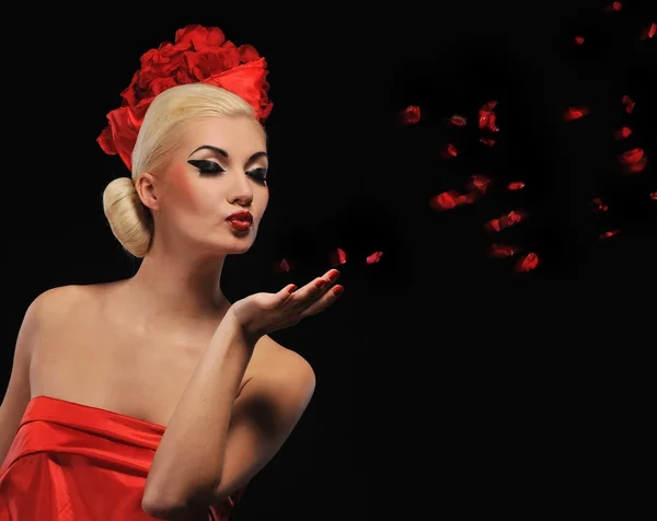 Vacker kvinna blåser rosenblad — Stockfoto