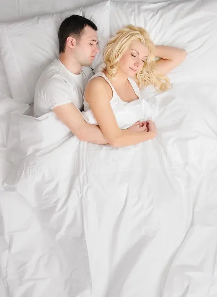 Junges Paar schläft in einem Bett — Stockfoto