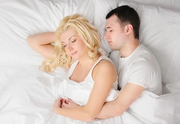 Jeune couple dormant dans un lit — Photo