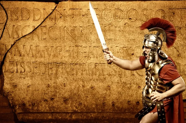 Romersk legionary soldat framför abstrakta vägg — Stockfoto
