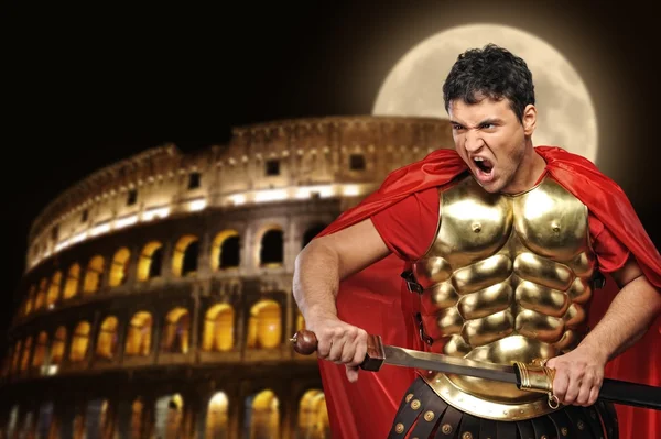 Soldado legionario romano frente al coliseo por la noche —  Fotos de Stock