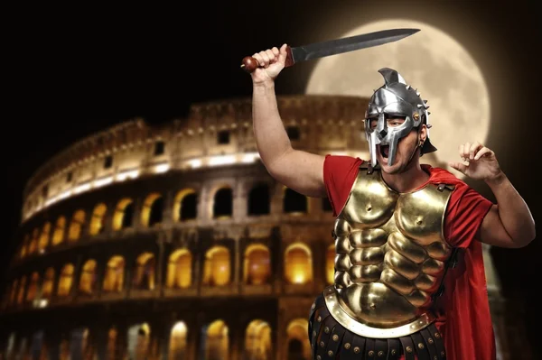 Soldato legionario romano di fronte al coliseum di notte — Foto Stock