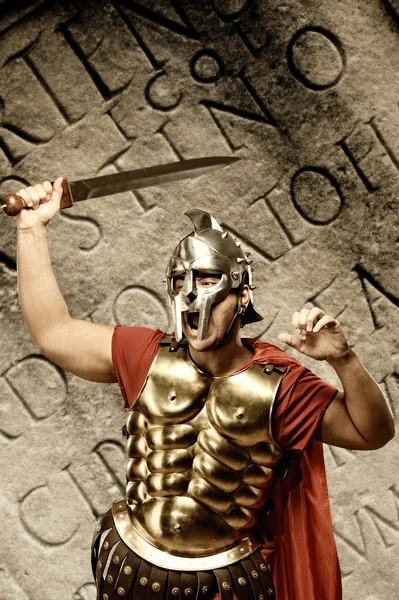 Soldado legionário romano na frente da parede abstrata — Fotografia de Stock