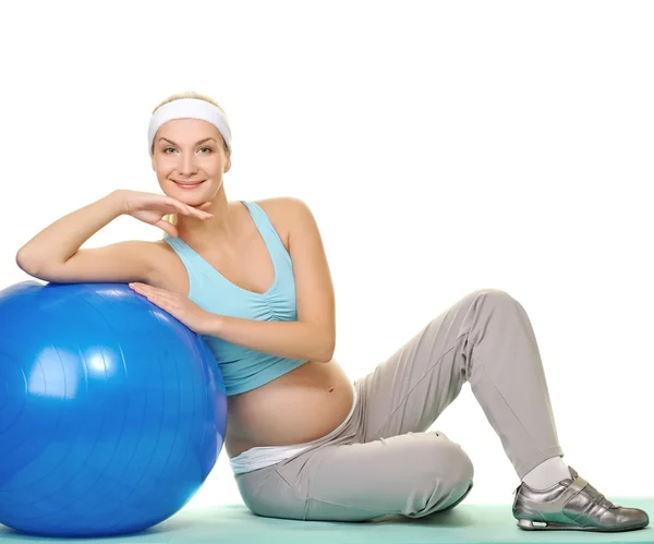 Jovem grávida fazendo exercício com uma bola de fitness — Fotografia de Stock