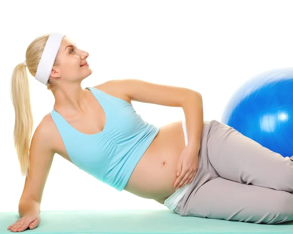 Jovem grávida fazendo exercício com uma bola de fitness — Fotografia de Stock