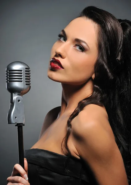 Portrait d'une belle brune avec un microphone rétro — Photo