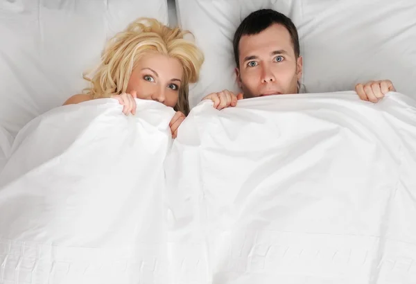 Roliga unga par i en säng — Stockfoto