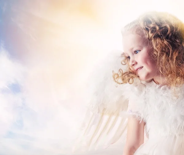Kleines Engelmädchen gegen sonnigen Himmel — Stockfoto