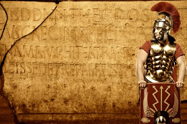 Roman legionary soldier in front of abstract wall — Stock Photo, Image