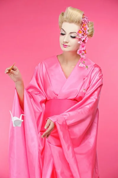 Vackra geisha håller origami fågel — Stockfoto