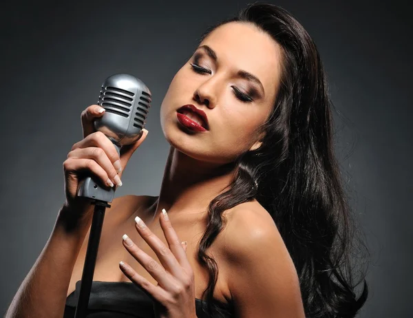Attractive brunette woman with a retro microphone — Stock Photo, Image