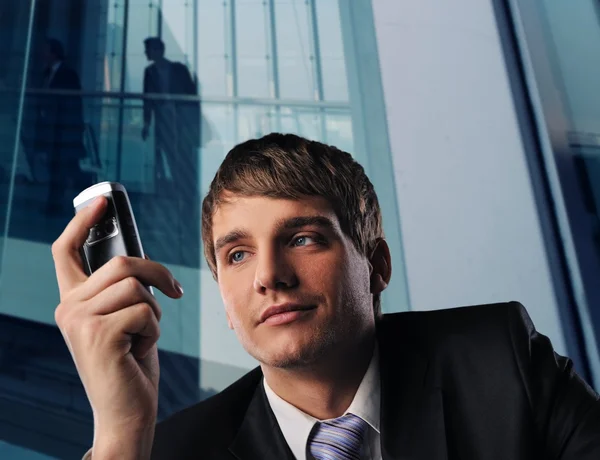Podnikatel s mobilním telefonem moderní kancelářské budovy — Stock fotografie