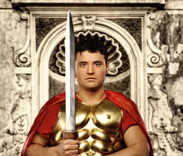 Romersk legionary soldat framför abstrakta vägg — Stockfoto