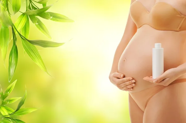 Kobieta w ciąży z butelki oleju — Zdjęcie stockowe
