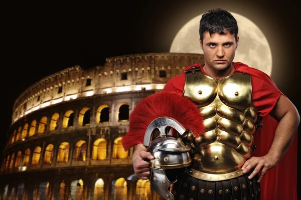 Roman legionary soldier in front of coliseum at night time Stock Photo