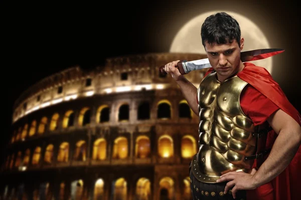 Roman legionary soldier in front of coliseum at night time Royalty Free Stock Photos