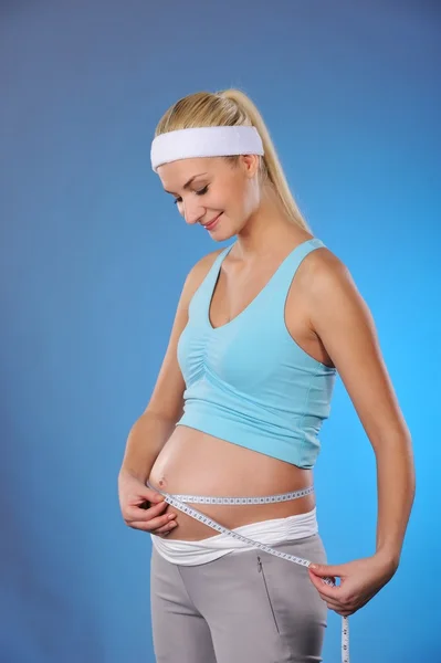 Hamile kadın göbeğini ölçer. — Stok fotoğraf