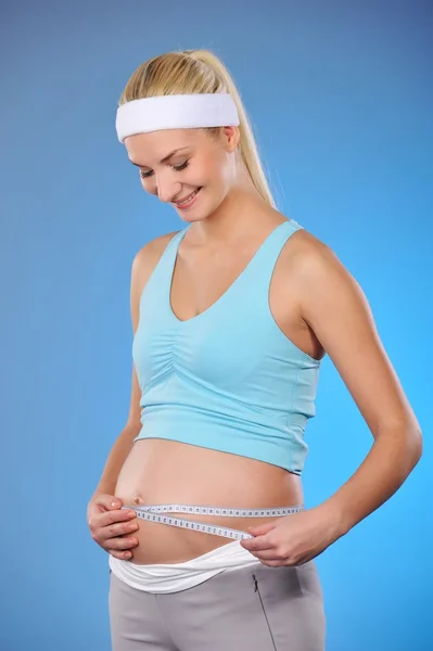 Pregnant woman measures her belly — Stock Photo, Image