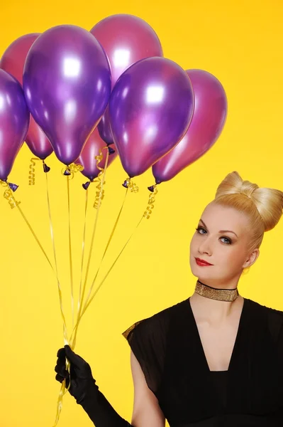 Schöne Dame mit einem Haufen lila Luftballons — Stockfoto