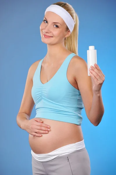 Mujer embarazada con una botella de aceite — Foto de Stock