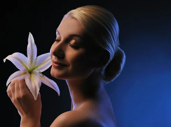 Piękna młoda kobieta z tonie w niebieski kwiat lilii — Zdjęcie stockowe