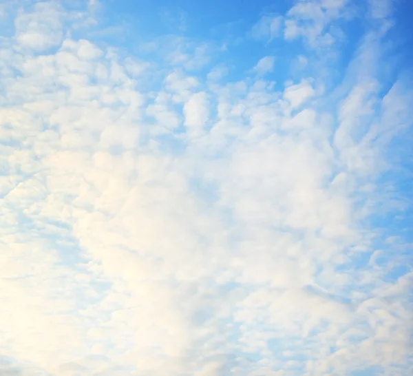 Blauwe lucht met pluizige wolken — Stockfoto