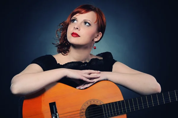 Atraktivní rusovláska žena s kytarou — Stock fotografie