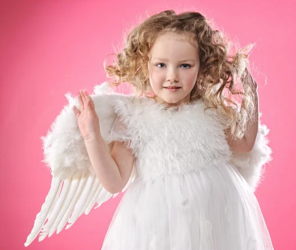 Schöne kleine Engelmädchen isoliert auf rosa Hintergrund — Stockfoto