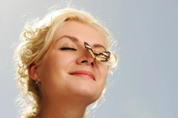 Bela borboleta sentada no nariz de uma mulher — Fotografia de Stock