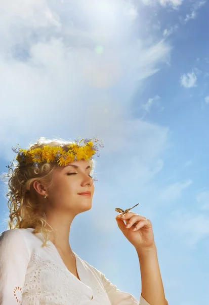 Прекрасна жінка з метеликом над блакитним небом — стокове фото