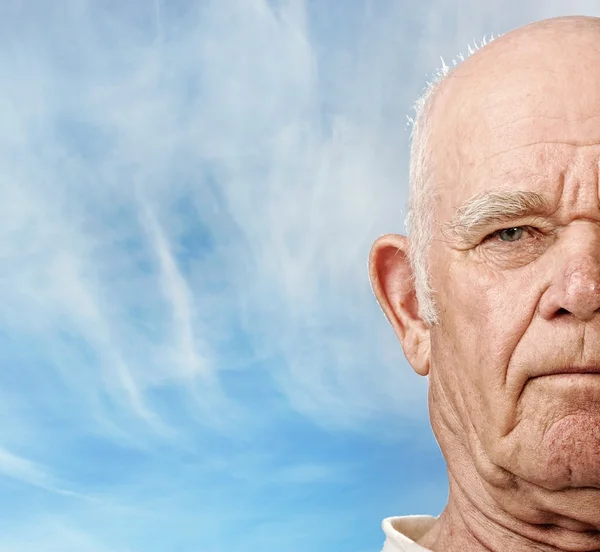 Oudere man gezicht over blauwe hemel — Stockfoto
