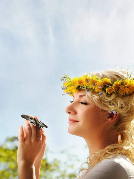 Mooie vrouw met een vlinder over blauwe hemel — Stockfoto
