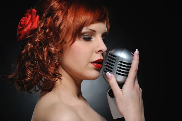 Attractive redhead woman with retro microphone — Stock Photo, Image